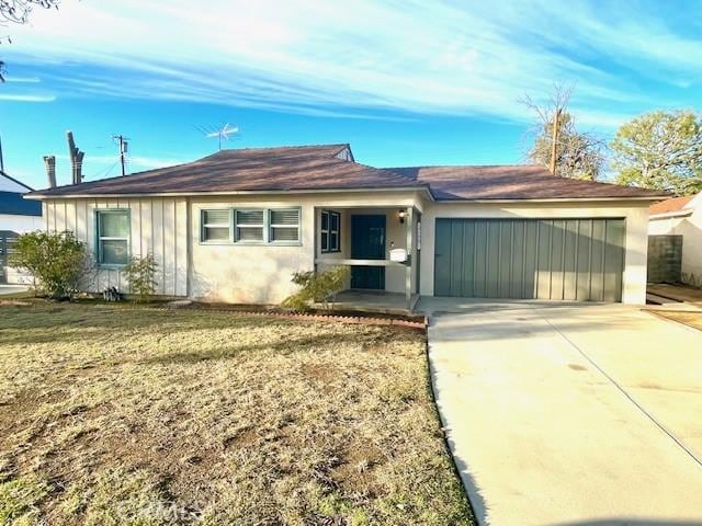 single story home with a garage and a front lawn