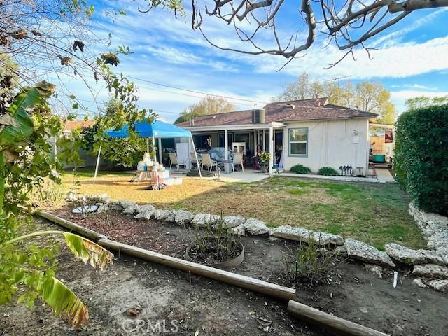 back of house with a yard and a patio area