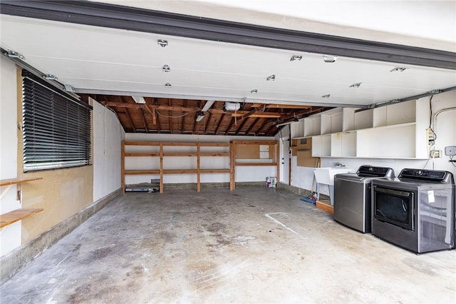 garage with a garage door opener, separate washer and dryer, and sink