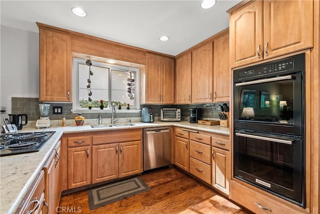 kitchen with dark hardwood / wood-style flooring, sink, tasteful backsplash, and appliances with stainless steel finishes