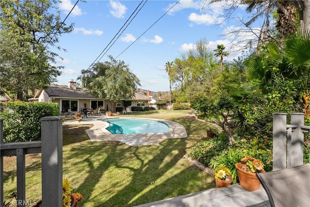 view of pool with a patio and a lawn