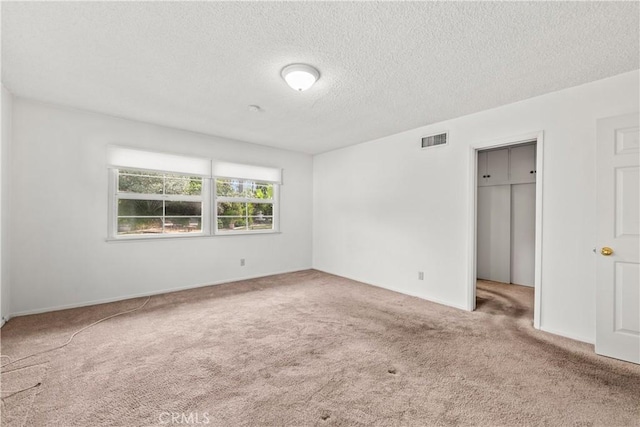 unfurnished bedroom with carpet floors and a textured ceiling