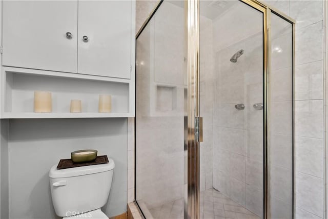 bathroom with toilet and a shower with door