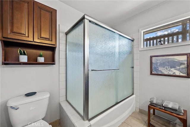 bathroom featuring tile patterned floors, enclosed tub / shower combo, and toilet