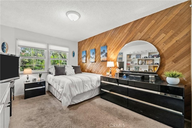 carpeted bedroom with wooden walls and a textured ceiling