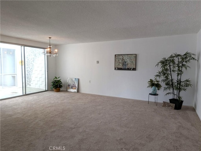 carpeted empty room with a notable chandelier and a textured ceiling