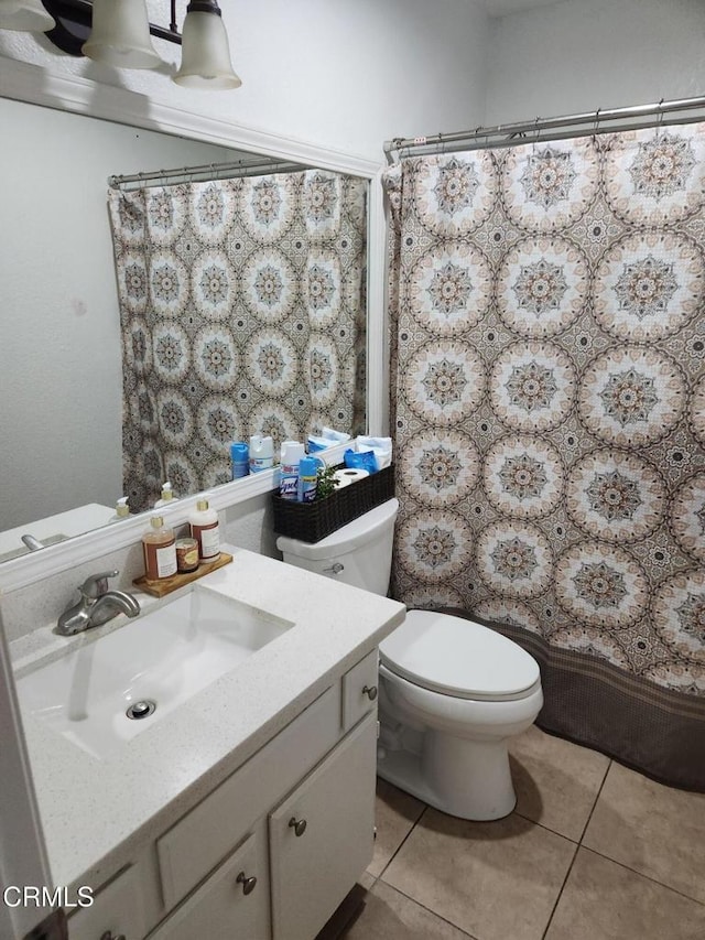 bathroom featuring walk in shower, vanity, toilet, and tile patterned flooring