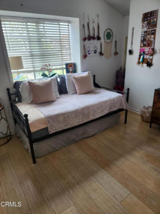 bedroom with lofted ceiling and light hardwood / wood-style flooring