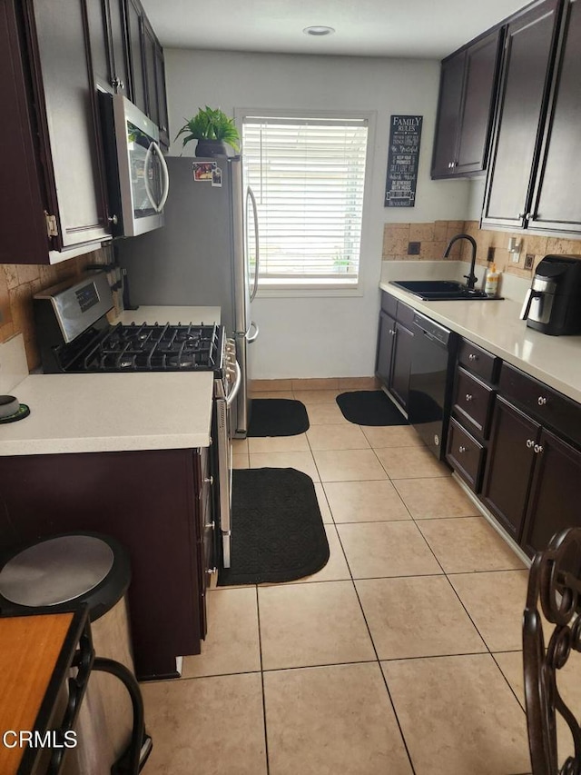 kitchen featuring tasteful backsplash, appliances with stainless steel finishes, sink, and light tile patterned floors