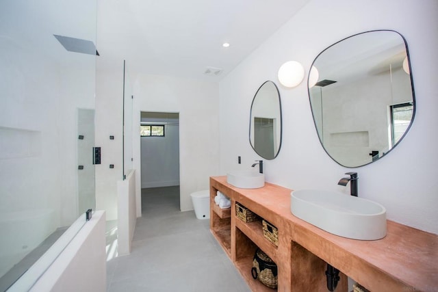 bathroom with vanity, concrete flooring, toilet, and a shower