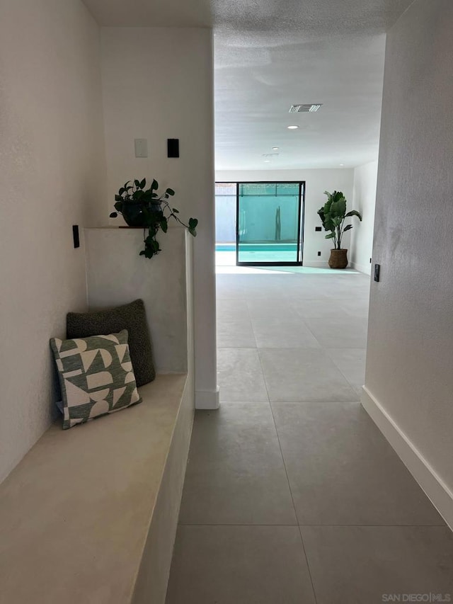 hall featuring light tile patterned floors