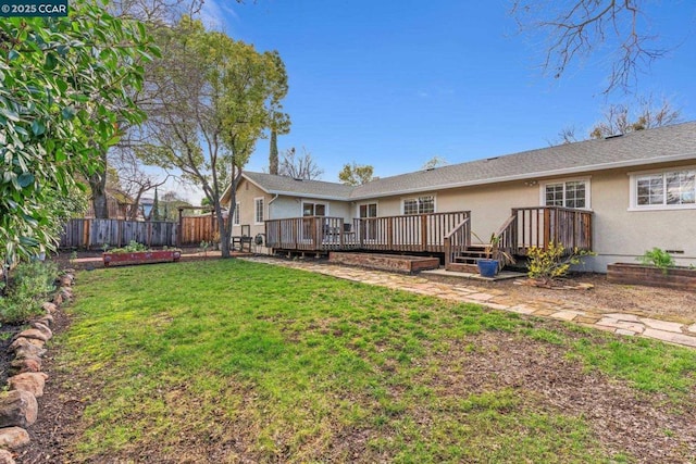 rear view of house featuring a lawn and a deck