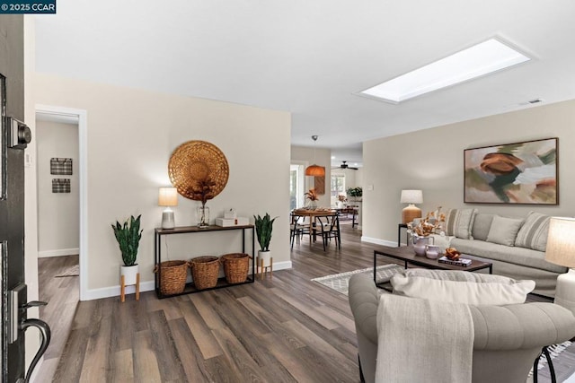 living room featuring dark wood-type flooring and a skylight