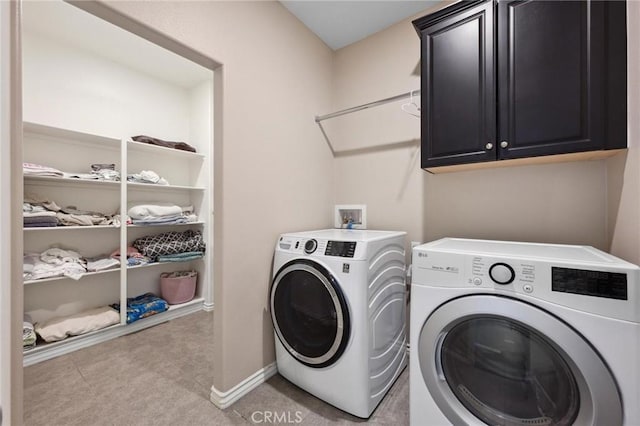 laundry room with washer and clothes dryer and cabinets