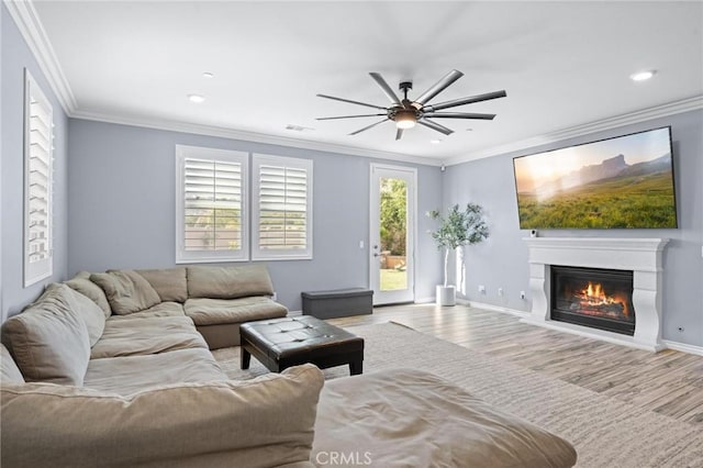 living room with ceiling fan, ornamental molding, and light hardwood / wood-style floors