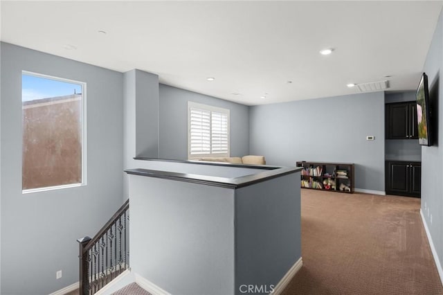 kitchen with light colored carpet and kitchen peninsula