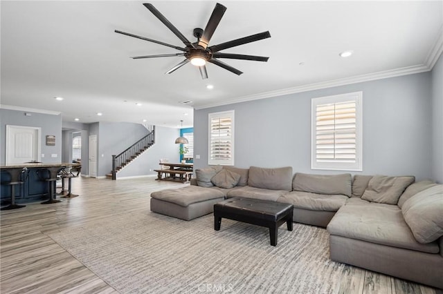 living room featuring ornamental molding, plenty of natural light, and light hardwood / wood-style floors