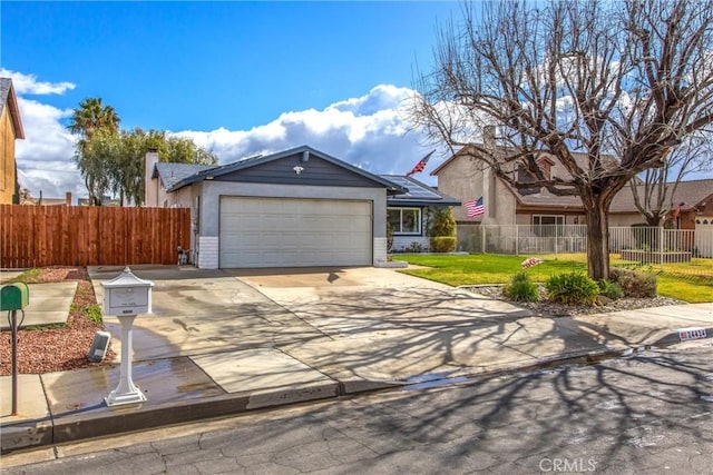 single story home with concrete driveway, a fenced front yard, an attached garage, a front lawn, and brick siding