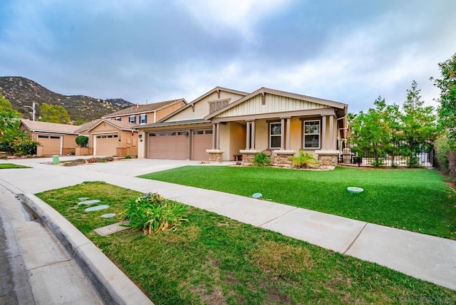 craftsman-style home with a garage, a mountain view, a front yard, and covered porch