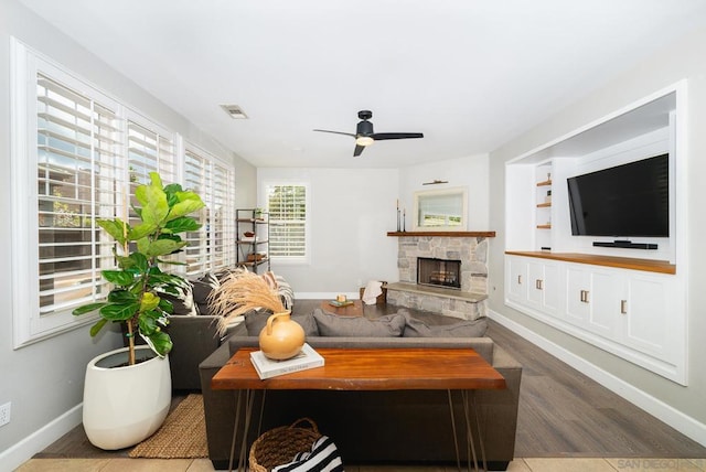 living room with ceiling fan, hardwood / wood-style floors, and a fireplace