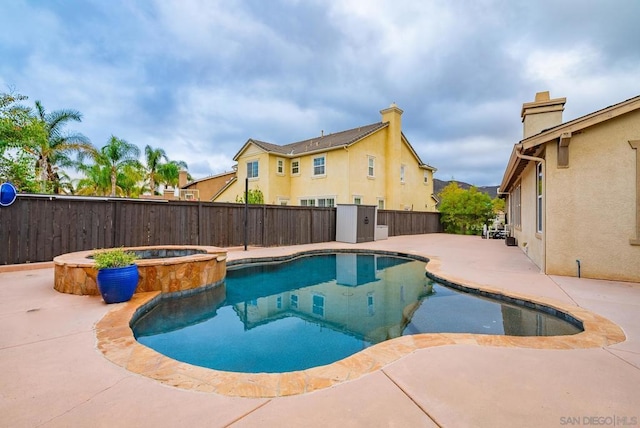 view of pool with an in ground hot tub and a patio