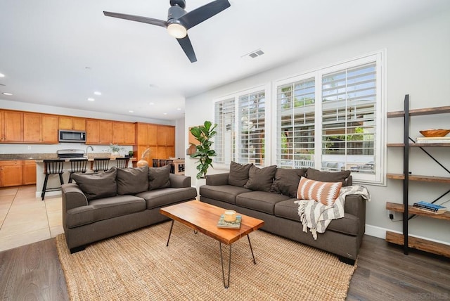 living room with ceiling fan and light wood-type flooring