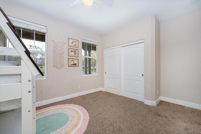 unfurnished bedroom featuring carpet, ceiling fan, and a closet