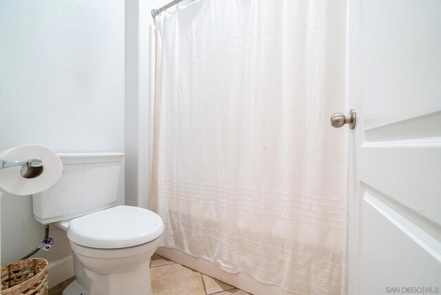 bathroom featuring tile patterned floors, toilet, and curtained shower