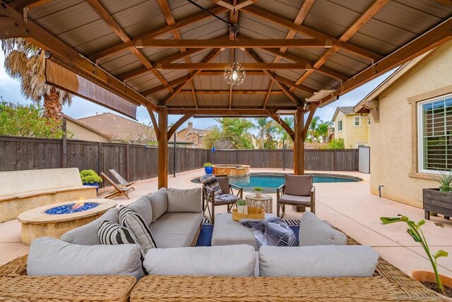 view of patio with a gazebo, an outdoor living space with a fire pit, and a pool with hot tub