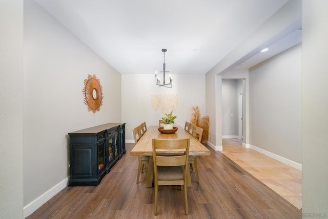 dining space with wood-type flooring and a chandelier