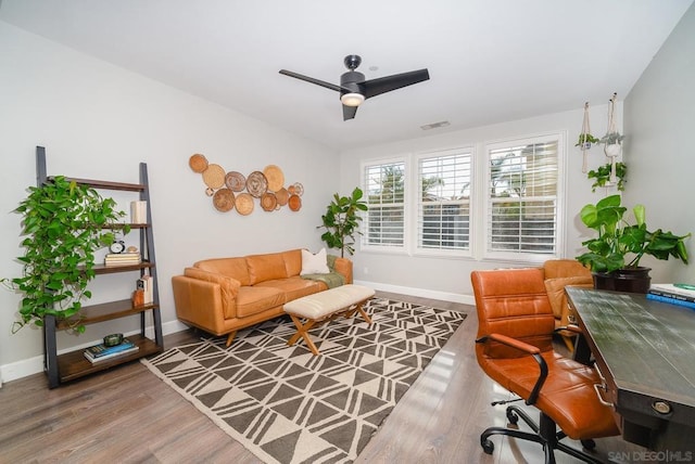 living area featuring wood-type flooring and ceiling fan