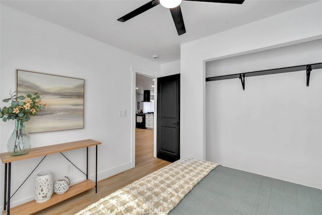 bedroom with ceiling fan, light hardwood / wood-style floors, and a closet