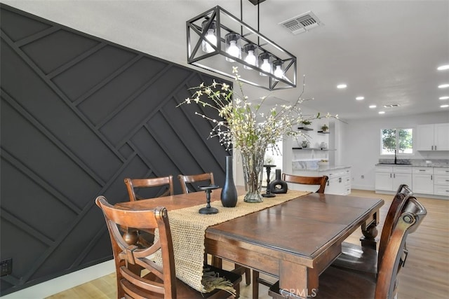 dining area with sink and light hardwood / wood-style floors