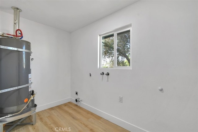 washroom with wood-type flooring, electric dryer hookup, washer hookup, and secured water heater