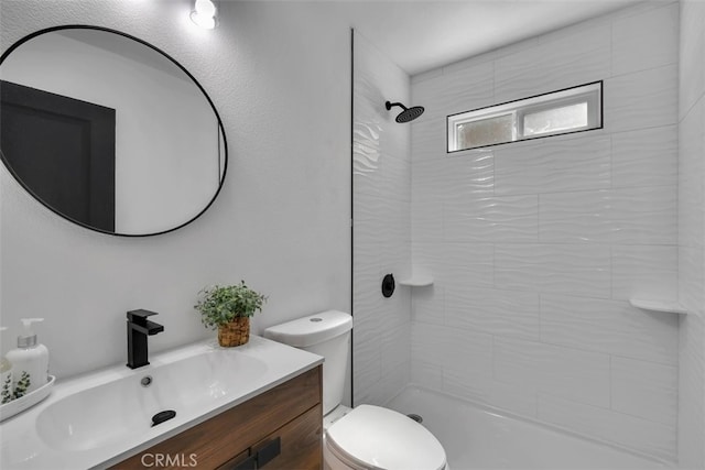 bathroom with vanity, a tile shower, and toilet