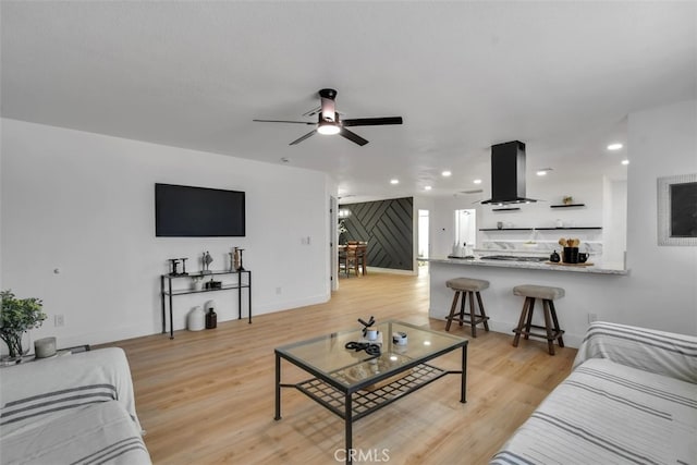 living room with ceiling fan and light hardwood / wood-style floors