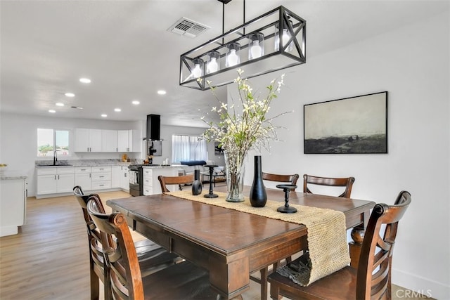 dining room with sink and light hardwood / wood-style floors