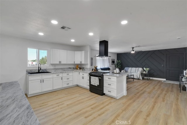 kitchen with sink, black range with electric stovetop, white cabinets, island exhaust hood, and kitchen peninsula