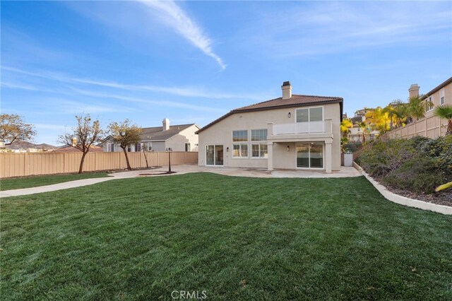 rear view of house featuring a patio and a lawn