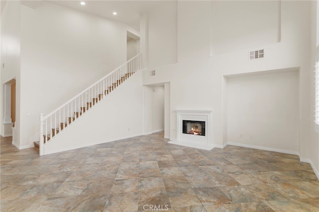 unfurnished living room with a high ceiling