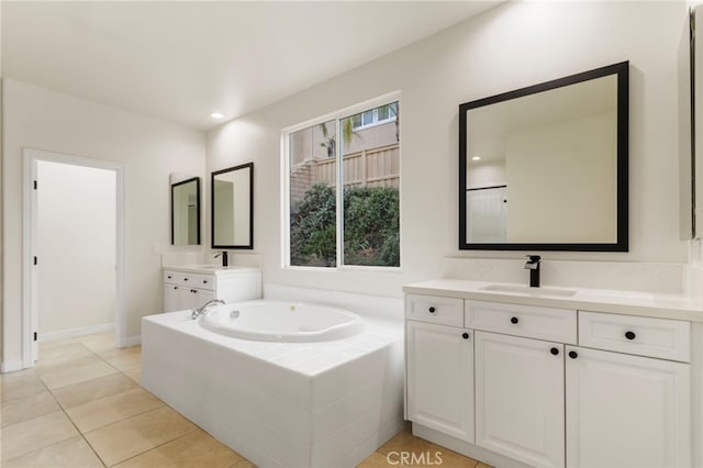 bathroom featuring tile patterned flooring, vanity, plenty of natural light, and tiled tub