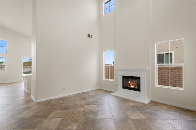 unfurnished living room with a towering ceiling