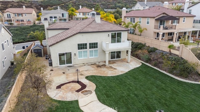 back of house with a yard, a patio area, and a balcony