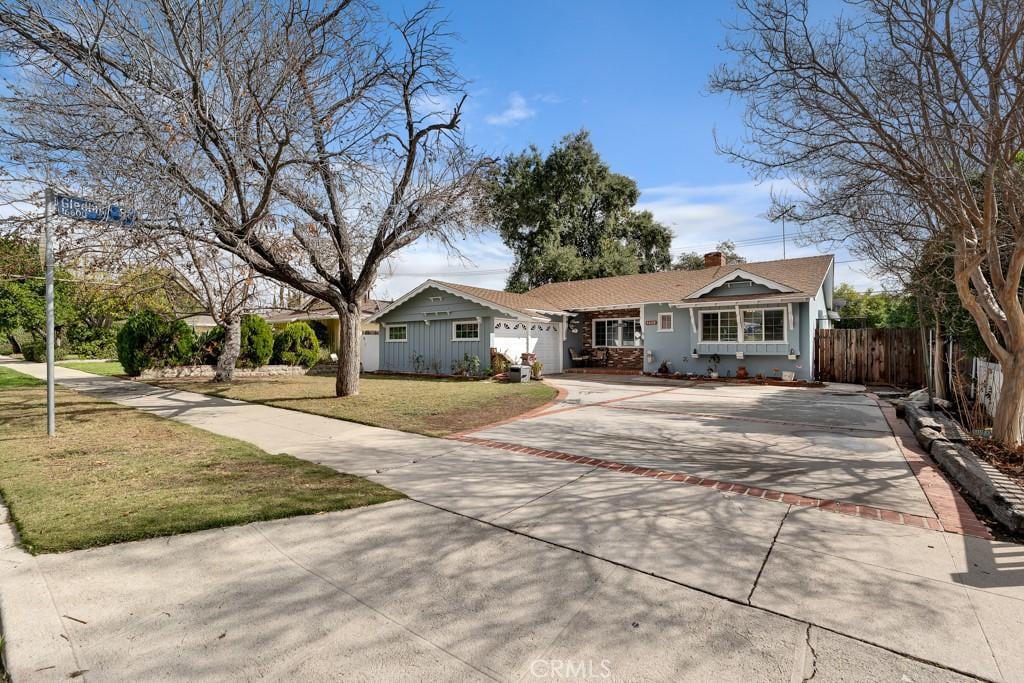 ranch-style house with a garage and a front lawn