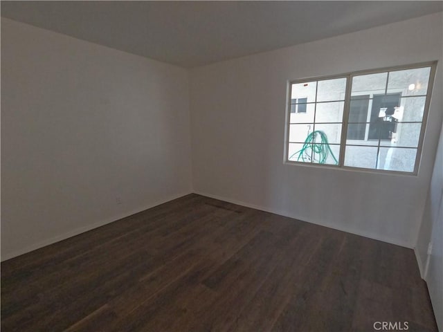 empty room with dark hardwood / wood-style flooring