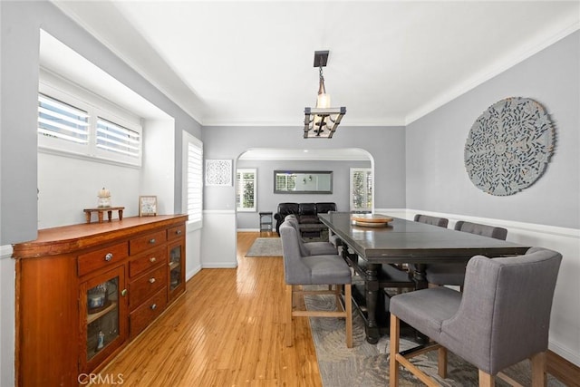 dining space with crown molding, a healthy amount of sunlight, and light hardwood / wood-style flooring