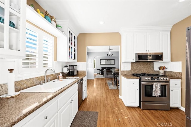 kitchen with white cabinetry, appliances with stainless steel finishes, sink, and light hardwood / wood-style floors