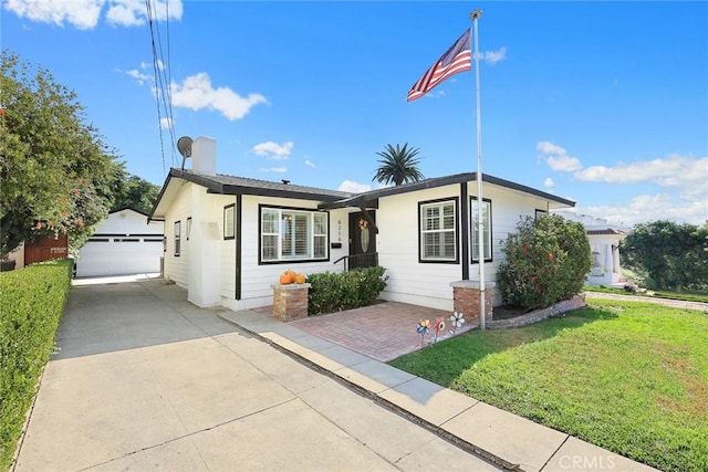 view of front facade with a garage, an outdoor structure, and a front yard