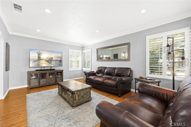 living room featuring crown molding and light hardwood / wood-style flooring