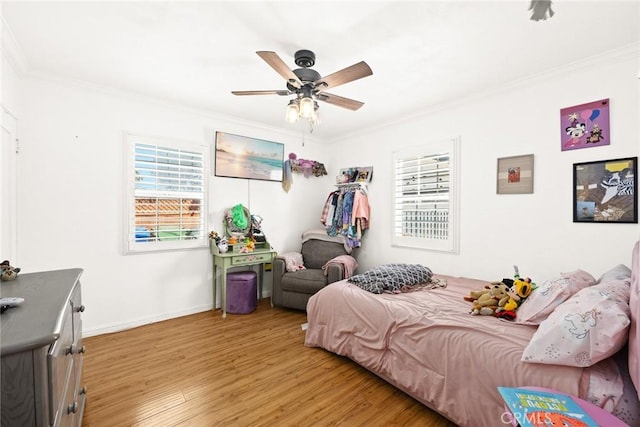 bedroom with crown molding, ceiling fan, and light hardwood / wood-style flooring